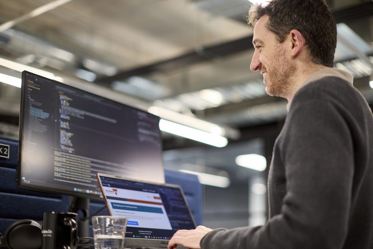 Conduct software developer coding at dual monitor workstation