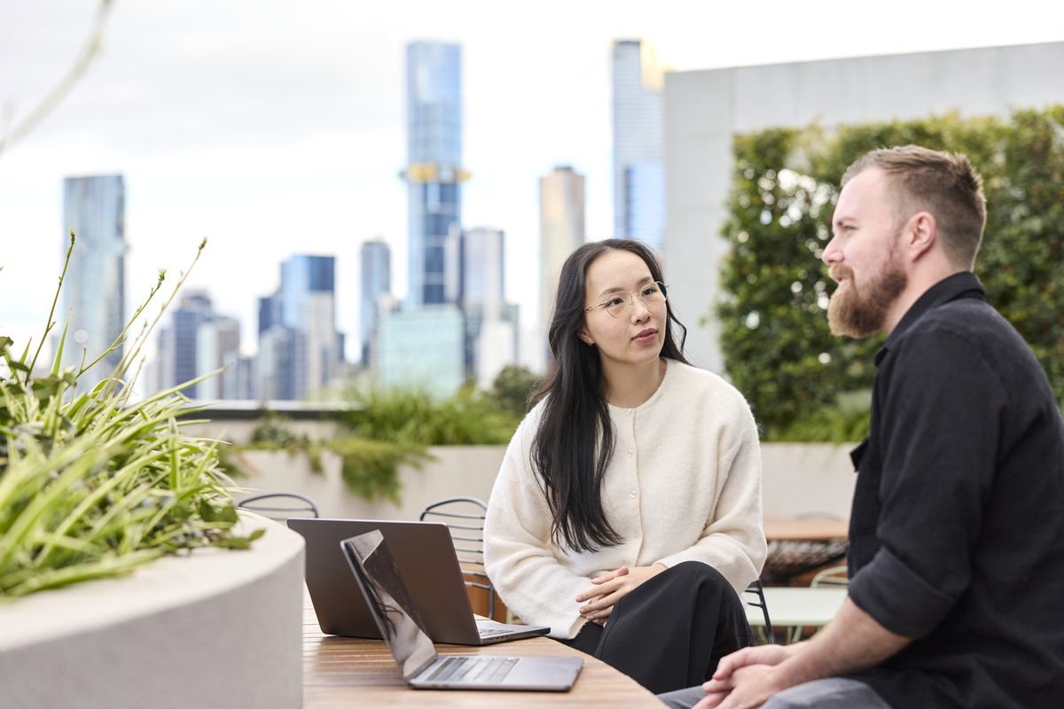 Conduct team working on Melbourne rooftop with city skyline