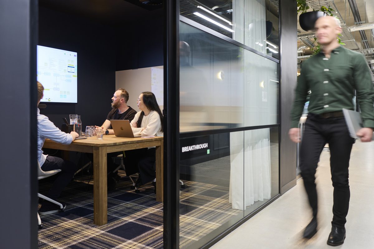 Conduct design studio meeting room with team collaborating