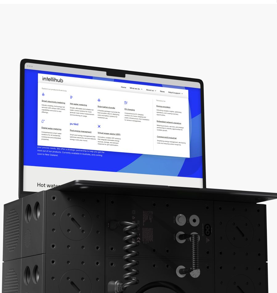 IntelliHub website mega menu showing products, services and audience navigation on laptop with smart meter hardware