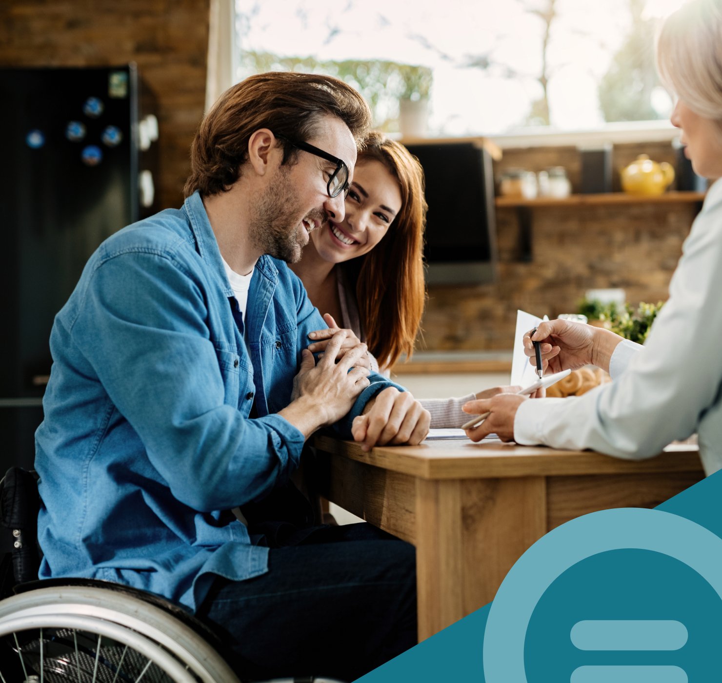 A couple including a man using a wheelchair talking with a Yooralla support worker at a kitchen table