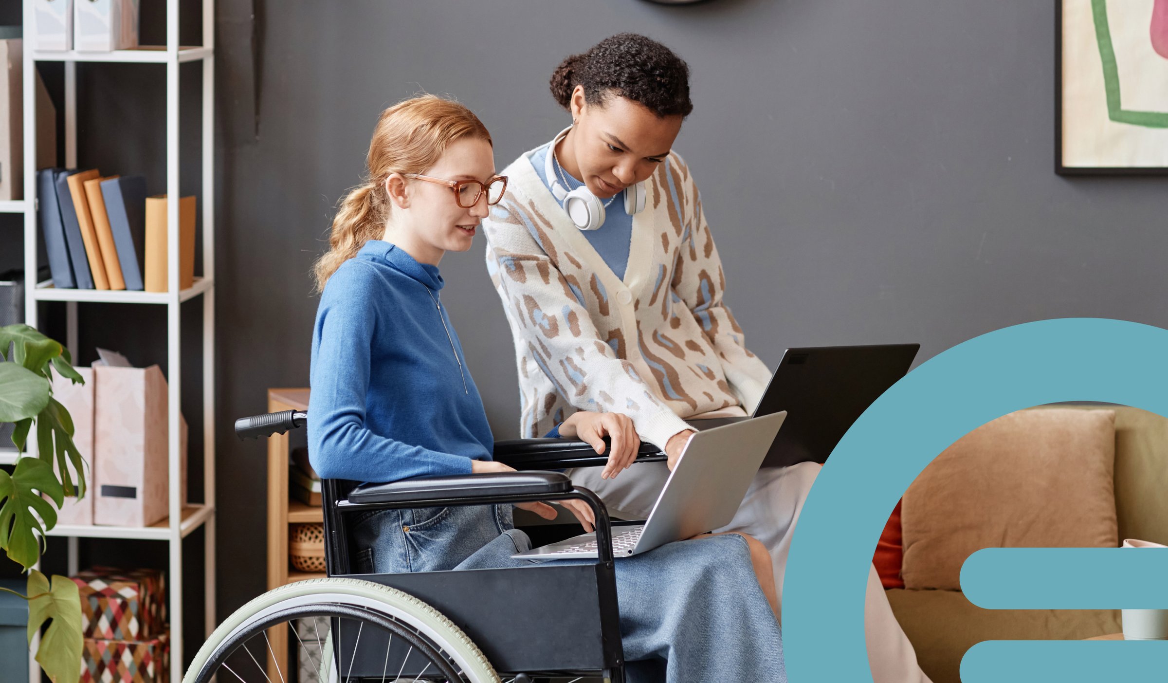 A Yooralla support worker collaborating with a wheelchair user on a laptop in a home setting